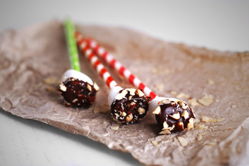 Tasty marshmallows with chocolate on sticks, close up