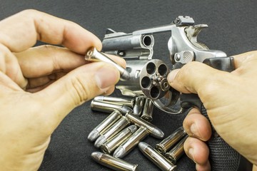 The .38mm and 9mm. bullet on hand reloading to a Revolver hand gun on black background. - weapon  © KissShot