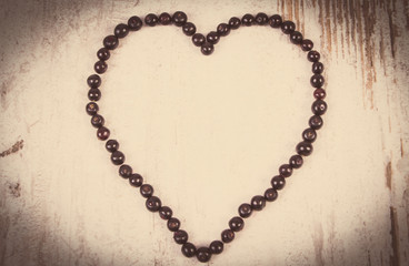 Vintage photo, Heart of fresh elderberry on old wooden background, symbol of love