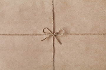 String or twine tied in a bow on kraft paper texture