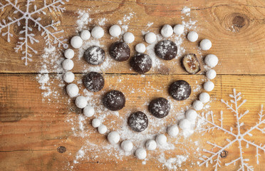 Candy in heart shape on wooden background