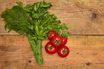 parsley, dill and tomatoes on wooden background