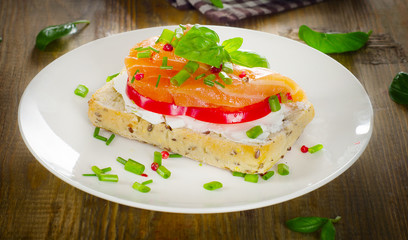 Sandwich with cereals bread and salmon on a old wooden backgroun