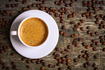 hot cup of coffee and coffee beans on the old wooden table