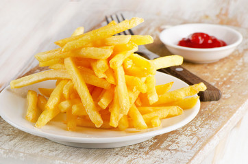 French fries on wooden board.