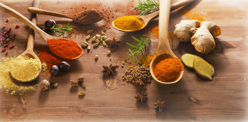 Spices and herbs on a wooden background.