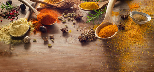 Various spices and herbs on wooden board.