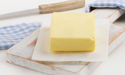 Butter on a white wooden board.