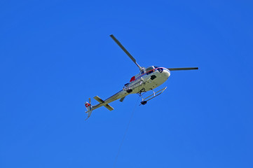 underside of utility helicopter with lifting cable