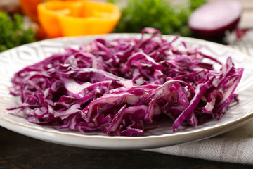 Red cabbage salad served on plate closeup