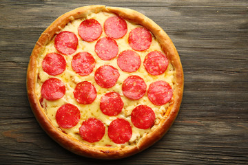 Tasty pizza with salami on wooden background