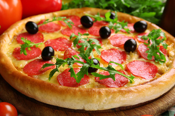 Tasty pizza with salami on decorated wooden table, close up
