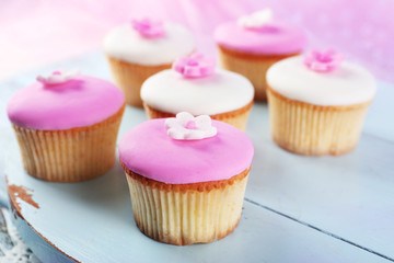Tasty cupcakes on color wooden background