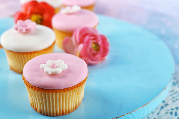 Tasty cupcakes on color wooden background