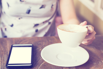 hand woman using smartphone in coffee shop and soft light with v