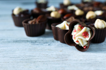 Delicious chocolate candies on wooden table, close up