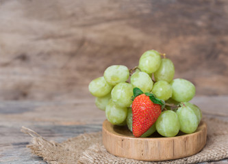 Grapes and strawberry fruit set on wood tray with old wooden bac