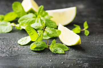Fresh lemon anf green mint on the black table