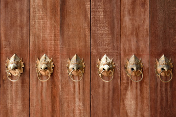 Wooden door with gold garuda head shaped door handles