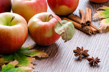 Fototapeta na wymiar Apples with leaves, cinnamon sticks, star anise and autumn leave