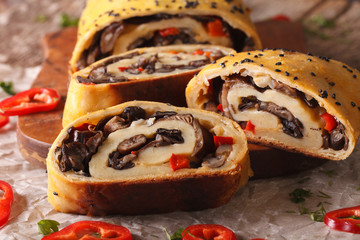 Strudel stuffed with wild mushrooms close-up on a board. horizontal
