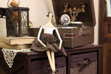 Handmade doll tilda in the coffee with polka dots dress and black hair. Interior dolls