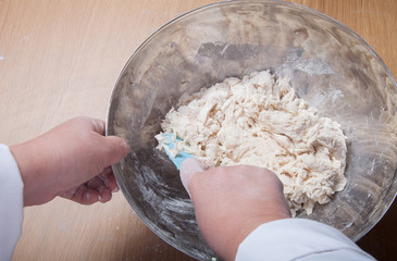 Woman's hands knead dough. Selective focus