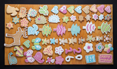 Gingerbread homemade cookies with icing colored drawings on wood