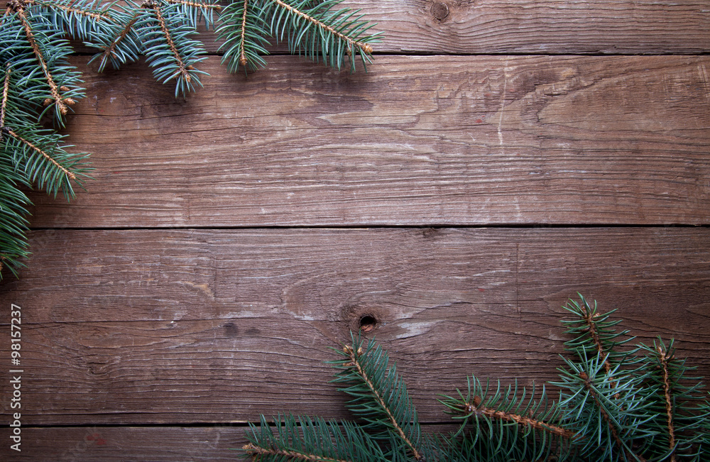 Wall mural Christmas tree branch on a wooden table or board for background.