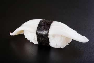 Nigiri sushi with squid on black background