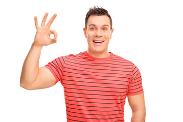 Fototapeta premium Joyful young man making an OK hand sign