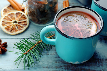 Tasty mulled wine and spices, on blue wooden background, close-up