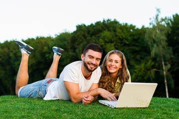 Young couple playing in games on laptop.