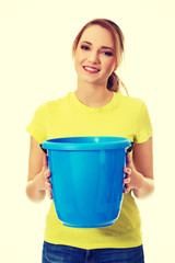 Young woman holding blue bucket.