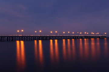 Fototapeta na wymiar The longest pier in Poland. Misty pier at night. Colorful night on pier.