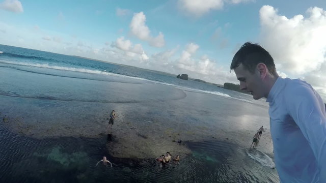 Slow motion selfie footage of a man jumping to the ocean from a cliff.
