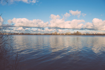 Obraz na płótnie Canvas White clouds over the river - vintage effect