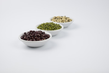 Fototapeta na wymiar Black eye peas, mung bean and adzuki beans in white bowl on white background