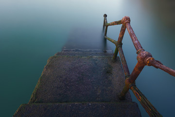 rusty handrail going down on water