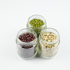 Black eye peas, mung bean and adzuki beans in a mason jar over white background