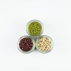 Black eye peas, mung bean and adzuki beans in a mason jar over white background
