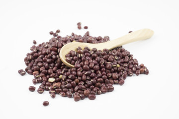 Adzuki beans over wooden spoon on white background