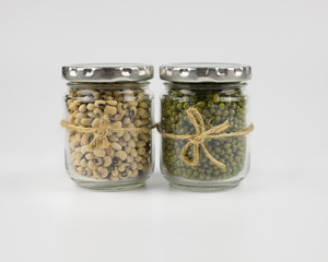 Black eye peas and mung beans in a mason jar over white background