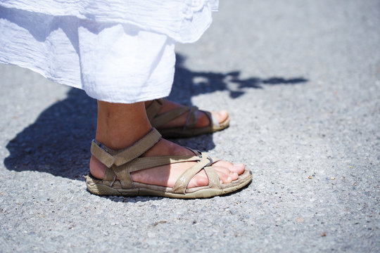woman stands in sandals on the road, detail