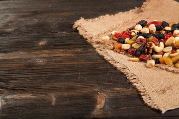 Dried fruits. Hazelnuts, almonds, cashews, apricots, cherries, walnuts, raisins. Background - burlap. Vintage.