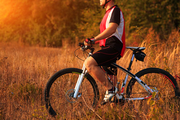 Plakat cyclist man cycling on a rural road during sunset