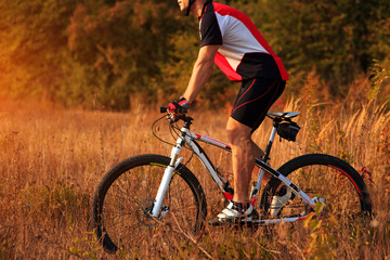 cyclist man cycling on a rural road during sunset