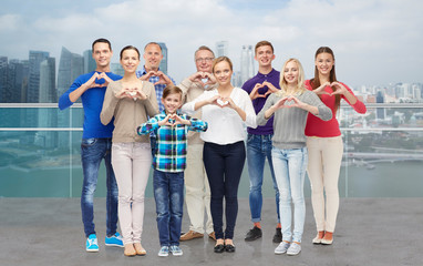 Obraz premium people showing heart hand sign over city waterside