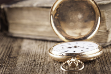 vintage pocket watch and book on wood still life