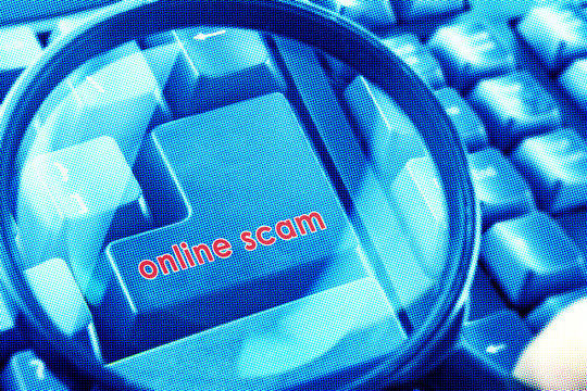 Magnifying glass on keyboard with Online Scam word on button. Color halftone effect applied.